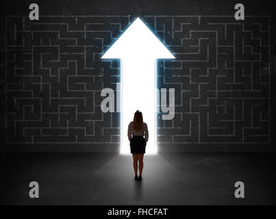 Persona d'affari guardando un labirinto con soluzione freccia sulla parete Foto Stock