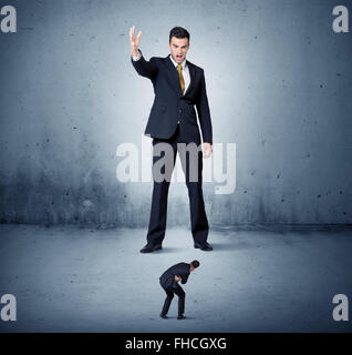 Arrabbiato enorme business man lokking al piccolo ragazzo Foto Stock