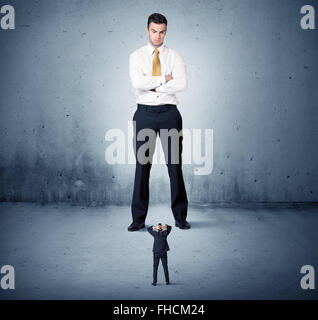 Arrabbiato enorme business man lokking al piccolo ragazzo Foto Stock