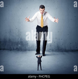 Arrabbiato enorme business man lokking al piccolo ragazzo Foto Stock