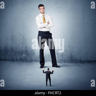 Arrabbiato enorme business man lokking al piccolo ragazzo Foto Stock