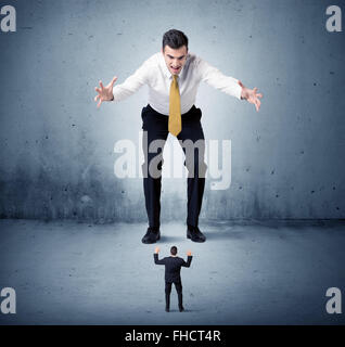 Arrabbiato enorme business man lokking al piccolo ragazzo Foto Stock