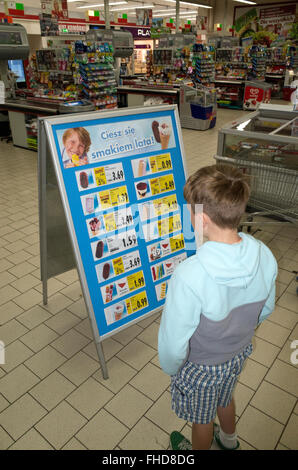 Ragazzo studiare gelato listino prezzi telaio a bordo in un negozio di alimentari. Tomaszow Mazowiecki Polonia centrale Foto Stock