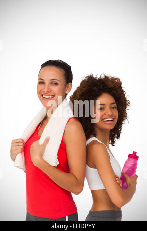 Immagine composita di montare le giovani donne in piedi con waterbottle e asciugamano Foto Stock