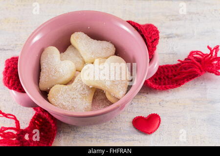 A forma di cuore biscotti in una ciotola rosa Foto Stock