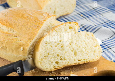 Home pane cotto al forno e un coltello sul tavolo Foto Stock