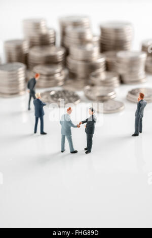 Imprenditori facendo una trattativa o prendendo tangenti per un grande mucchio di denaro con pile di denaro in background Foto Stock