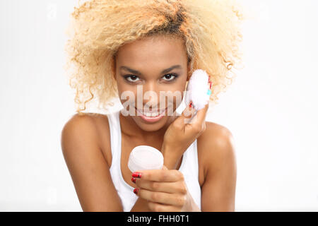 Giovane donna lavando la faccia con un bastoncino di cotone cosmetici. Clinique. Per la pulizia della pelle del viso con un tampone di cotone. Il trucco di lavaggio Foto Stock