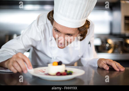 Lo Chef versando la salsa un dessert Foto Stock