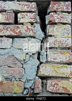 Rotto vecchio muro di mattoni su un impianto domestico. Foto Stock