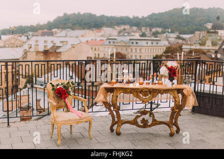 Luxury oriental-stile golden tavolo con sedia vintage sulla terrazza. Decorazioni per matrimoni Foto Stock