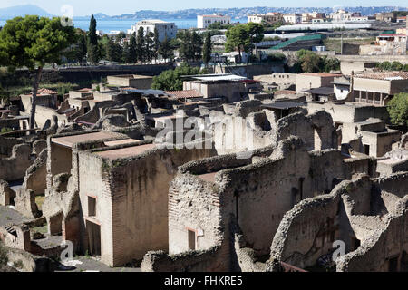 Ercolano rovine con la città moderna e il golfo di Napoli in background Foto Stock