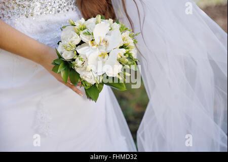 Sposa tenendo un bellissimo mazzo di fiori bianchi Foto Stock