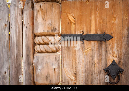 Close-up della vecchia porta di legno su cerniere in metallo Foto Stock