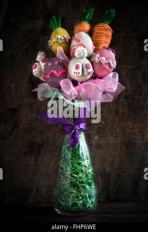 Vaso di pasqua con torta pop su sfondo di legno Foto Stock