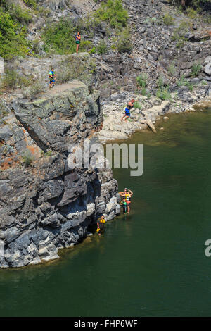 Persona che salta da una scogliera nel fiume Clark Fork in alberton gorge vicino Alberton, montana Foto Stock