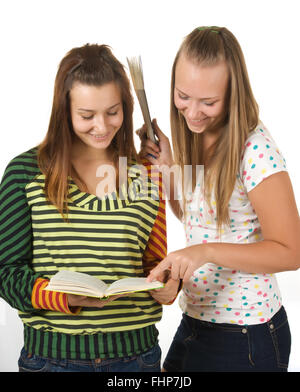 Due ragazze adolescenti sorridente e libro di lettura Foto Stock