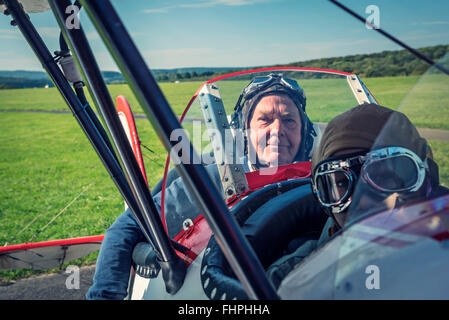 Germania, Dierdorf, nonno e nipote seduta sul vecchio biplano Foto Stock