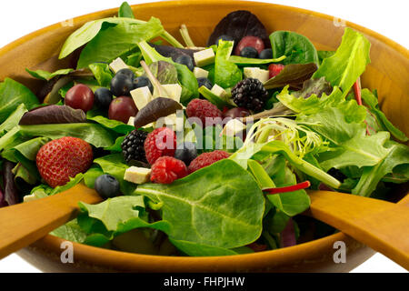 Organici di verdure miste, bacche e germogliato il tofu insalata servita nella ciotola di legno su sfondo bianco Foto Stock