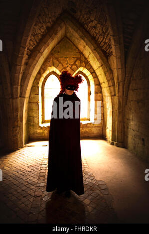Figura femminile che indossa parrucca rosso in piedi nel castello Foto Stock