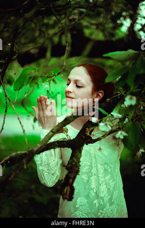 Giovane donna nella foresta tenendo una farfalla Foto Stock
