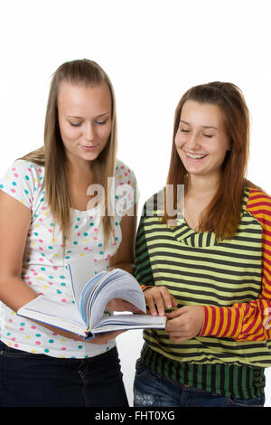 Due ragazze adolescenti sorridente e libro di lettura Foto Stock