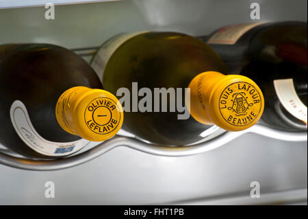 La Borgogna vino bianco bottiglia incapsulato cime di Olivier Leflaive & Louis Latour bianco vini della Borgogna controllato in temperatura armadio Foto Stock