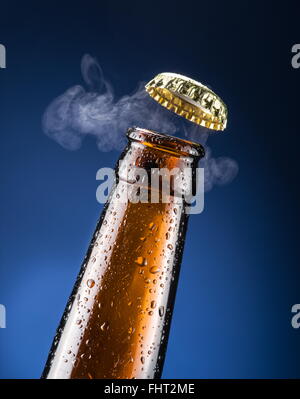 Apertura del tappo di birra con il gas in uscita. Foto Stock