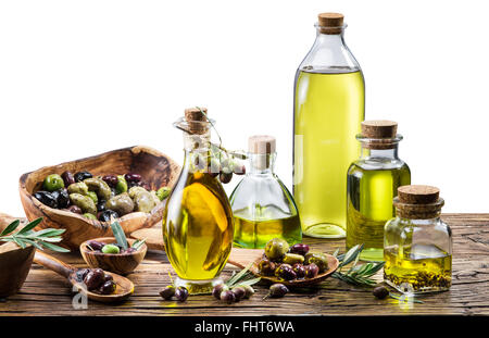 Olio di oliva e bacche sul tavolo di legno. sfondo bianco. Il file contiene i tracciati di ritaglio. Foto Stock