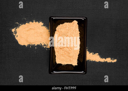 Polvere di maca su sfondo nero. Foto Stock