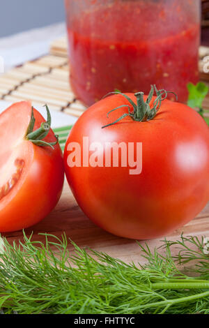 Rosso Pomodoro su una tabella con un vaso Foto Stock