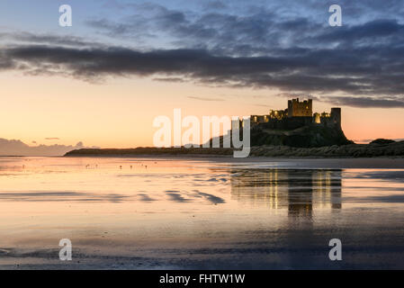 Il castello di Bamburgh e Spiaggia di Northumberland all'alba Foto Stock