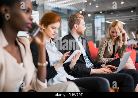 La gente di affari la conversazione con la tecnologia a portata di mano. Scambio di idee nuove e di brainstorming tra colleghi Foto Stock