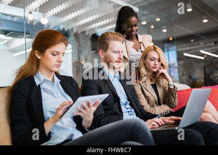 La gente di affari la conversazione con la tecnologia a portata di mano. Scambio di idee nuove e di brainstorming tra colleghi Foto Stock