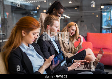 La gente di affari la conversazione con la tecnologia a portata di mano. Scambio di idee nuove e di brainstorming tra colleghi Foto Stock