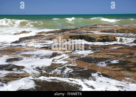 Onde che si infrangono sulle rocce in Imbassai beach - Costa nord Foto Stock