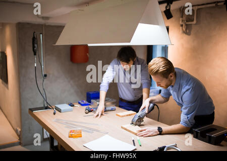 Due designer creativi che lavorano in officina con utensili di precisione la fabbricazione di un prodotto nuovo Foto Stock