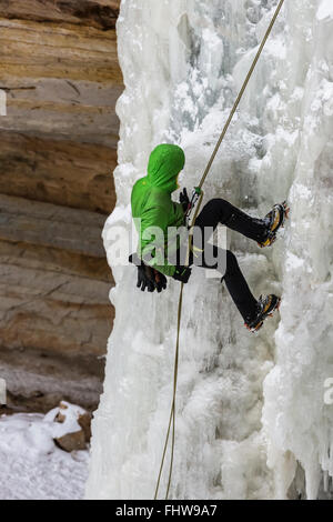 Ice Climber rappelling giù una cascata ghiacciata in Pictured Rocks National Lakeshore, Penisola Superiore, Michigan, Stati Uniti d'America Foto Stock