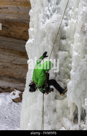 Ice Climber rappelling giù una cascata ghiacciata in Pictured Rocks National Lakeshore, Penisola Superiore, Michigan, Stati Uniti d'America Foto Stock