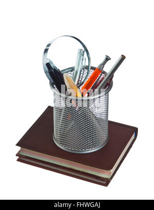 Cestello con matite e penne sul libro Foto Stock