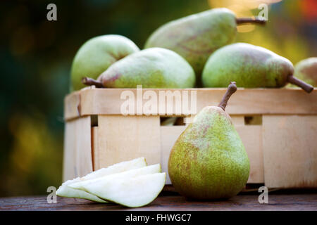 Mature pere biologiche in un cestello con pezzi di fette Foto Stock