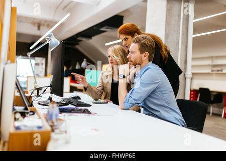 Progettisti che lavorano come un team in ufficio per discutere le tendenze future Foto Stock