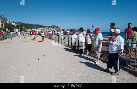 Partecipanti e spettatori ad un torneo di Boules sulla Promenade des Anglais a Nizza, Francia Foto Stock