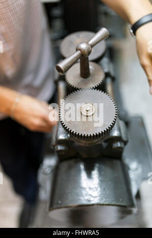 Goldsmith creazione di metallo con l'aiuto di una pressa Foto Stock