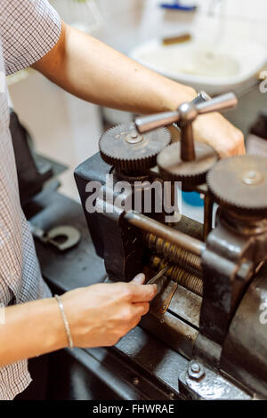 Goldsmith creazione di metallo con l'aiuto di una pressa Foto Stock