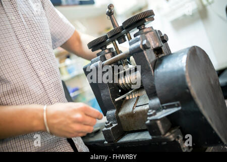 Goldsmith creazione di metallo con l'aiuto di una pressa Foto Stock