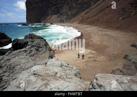 I visitatori di camminare sulla spiaggia dell'isola di Trinidad con oceano Atlantico in background Foto Stock