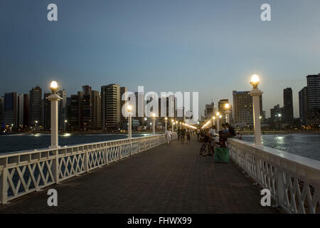 Al tramonto sul molo presso la spiaggia di Irachema waterfront con edifici in background Foto Stock