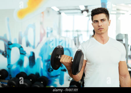 Uomo bello il sollevamento pesi in palestra e stare in forma Foto Stock