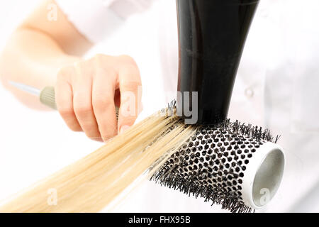 Pettinare i capelli a spazzola di essiccazione. La donna presso il parrucchiere, barbiere modelli capelli su una spazzola circolare. Parrucchiere capelli secchi Foto Stock